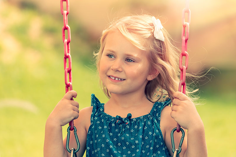 little-girl-is-riding-on-a-swing-PR9S7YH.jpg